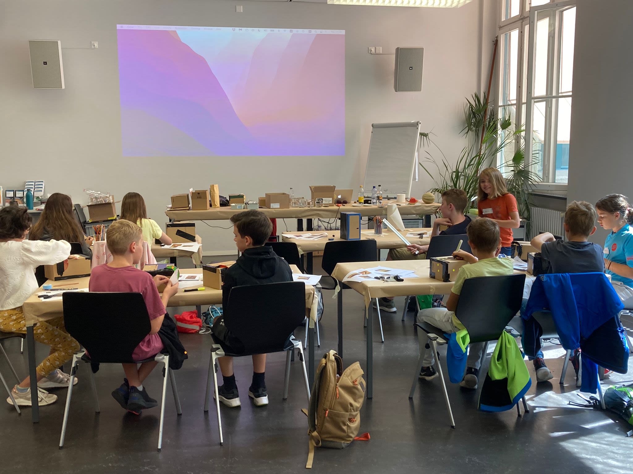 Kinder an Tischen in einem Workshop