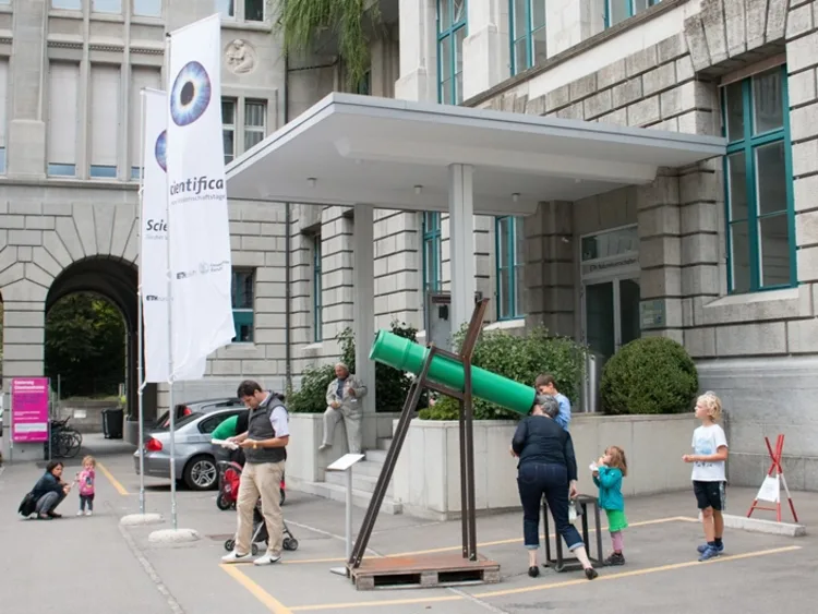 Besuchende blicken im Aussenbereich von focusTerra durch ein Teleskop.